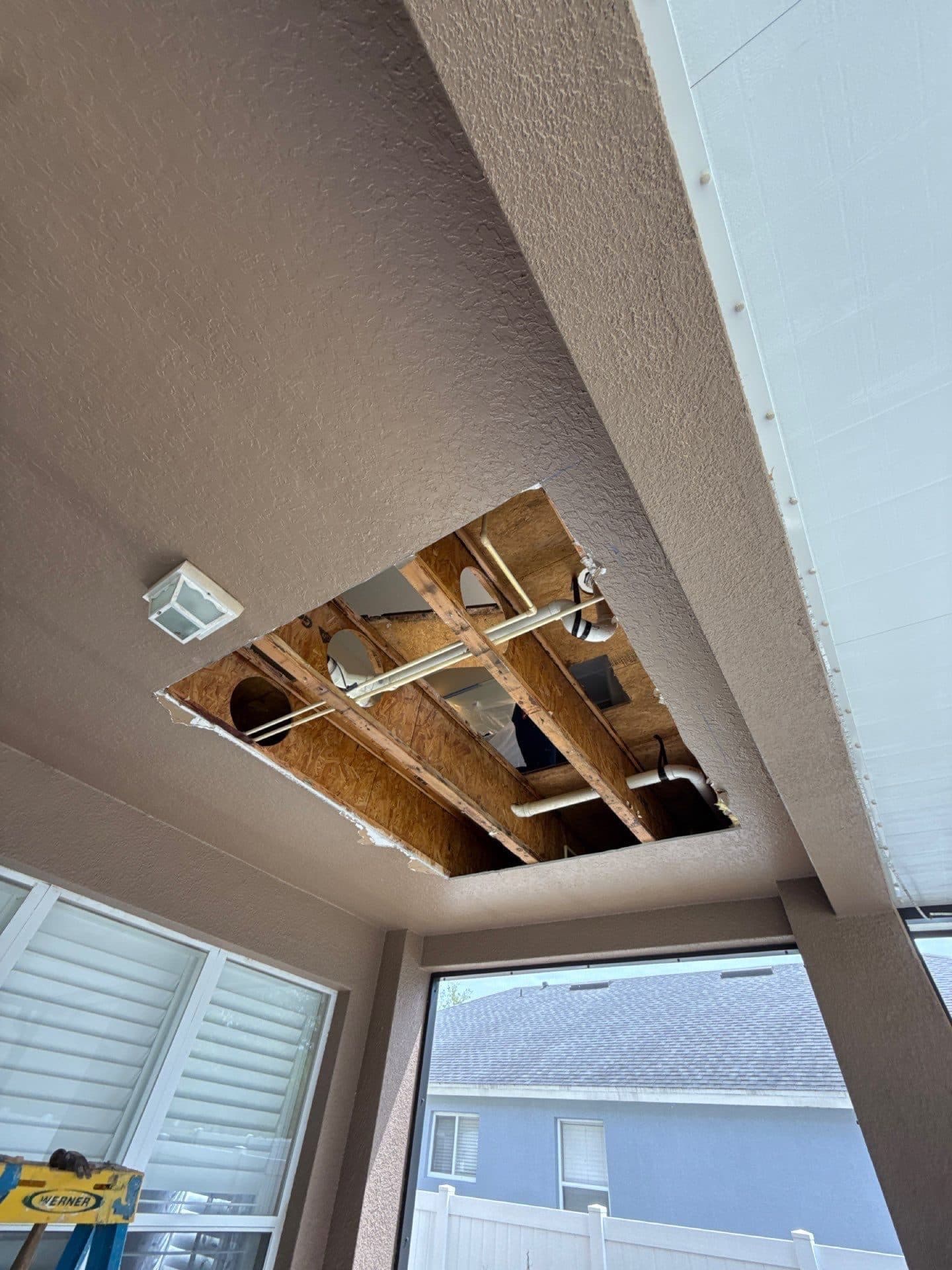 A ceiling opened up to reach water damage above